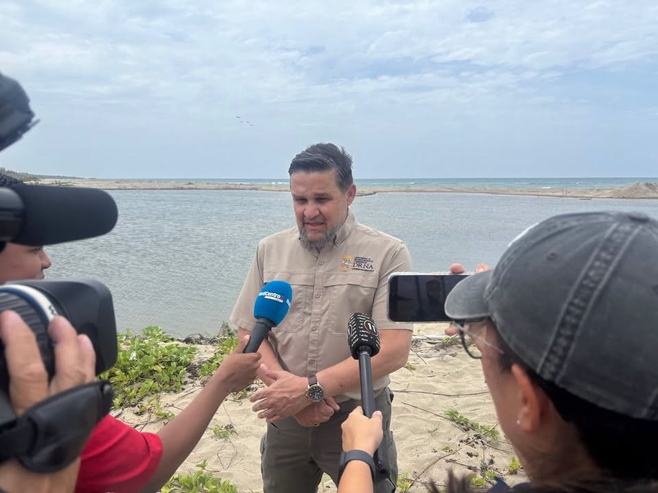 Waldemar Quiles, secretario del DRNA, habla con la prensa ante la desembocadura del Río Grande de Loíza, en Loíza, Puerto Rico, durante una actividad de dragado el 12 de junio del 2026 para rescatar dos manatíes que supuestamente estaban atascados. | Foto: suministrada, captura de pantalla.