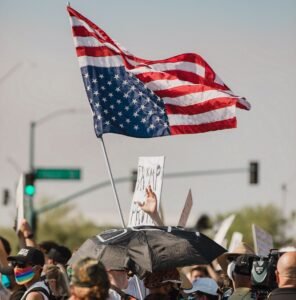 Protesta en Estados Unidos contra el régimen del presidente Trump porta una bandera invertida de la nación estadounidense. M Sides, Pexels.