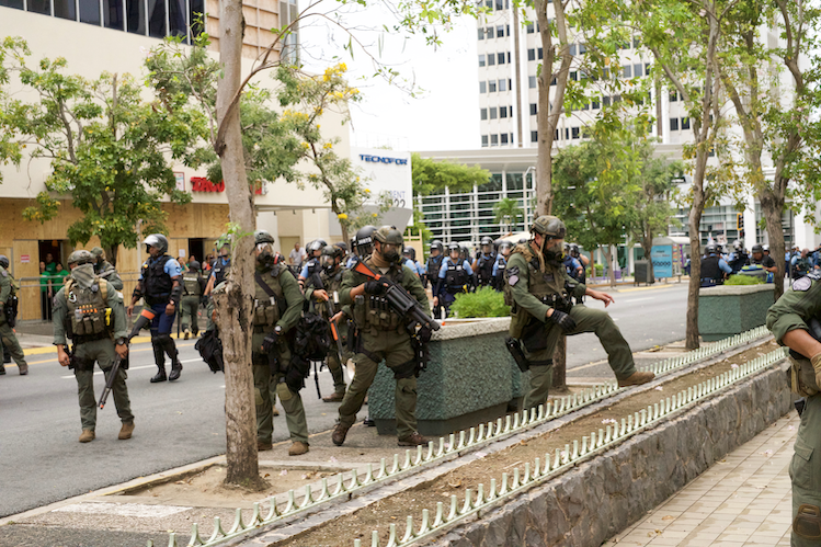 Foto: Unidad de Swat de la Policía de Puerto Rico persigue a manifestantes durante las protestas del 1 de mayo de 2017, en el sector financiero de San Juan conocido como la ‘Milla de Oro’. Sebastián Castrodad, Centro de Periodismo Investigativo
